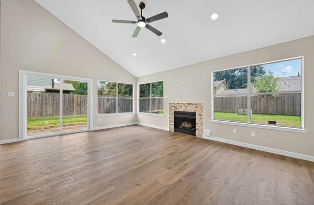 a view of an empty room with a fireplace and a window