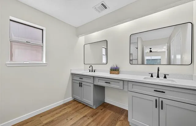 a bathroom with a double vanity sink and mirror