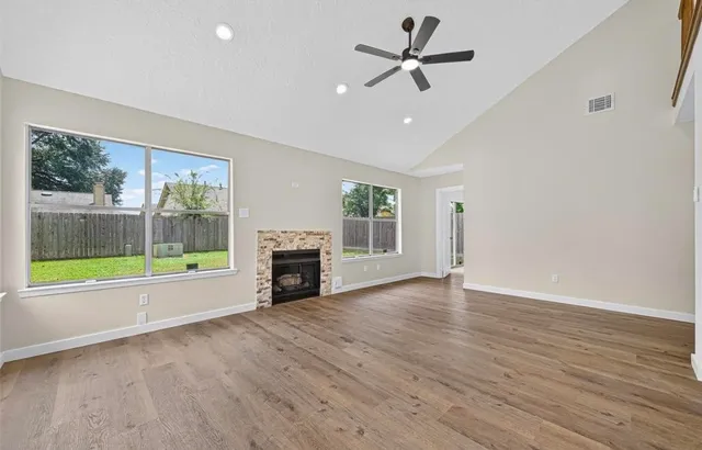 a view of an empty room with a fireplace and a window
