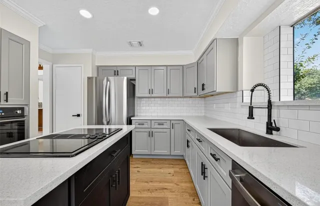 a kitchen with granite countertop a sink stove and refrigerator