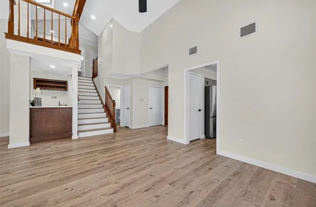 a view of a hallway with wooden floor and staircase