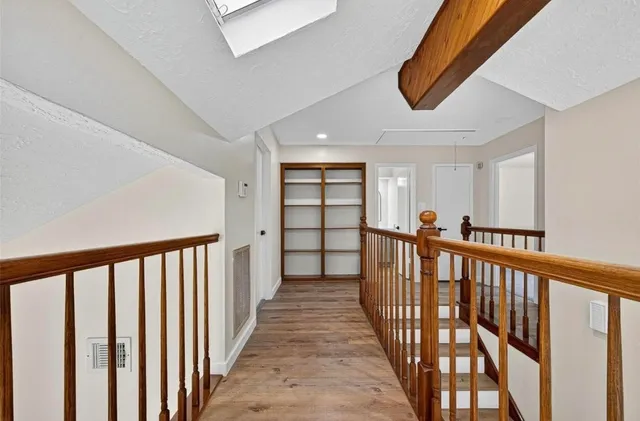 a view of a hallway with wooden floor and entryway