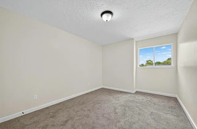a view of empty room with wooden floor and ceiling fan