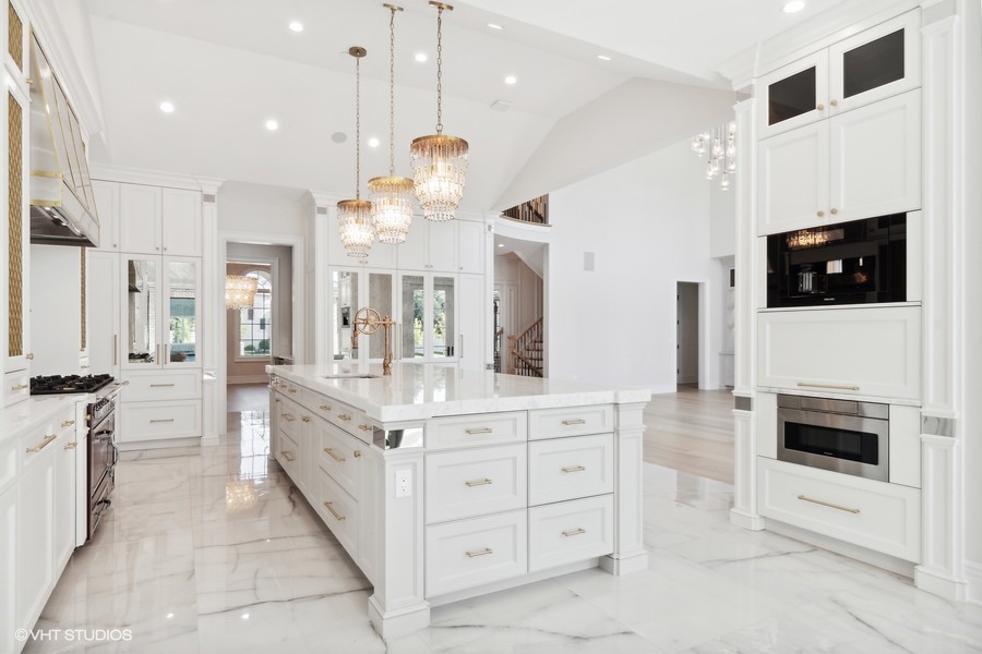 502 Greenwood Road Northbrook, IL 60062 - Photo 18 of 60 a large white kitchen with stainless steel appliances kitchen island granite countertop a refrigerator a stove a microwave oven a sink dishwasher and white cabinets with wooden floor