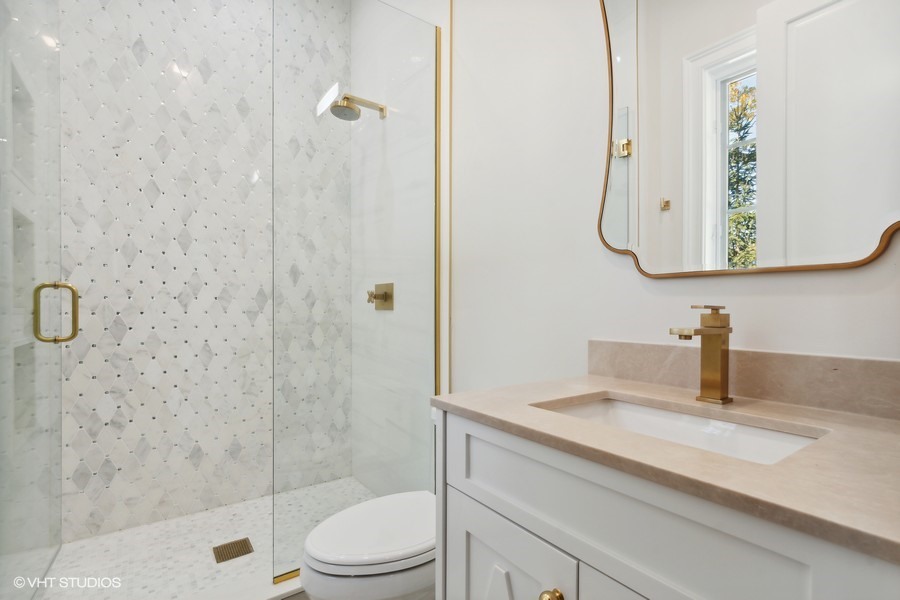 502 Greenwood Road Northbrook, IL 60062 - Photo 39 of 60 a bathroom with a granite countertop sink a toilet and shower