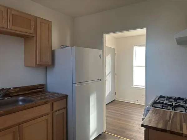 a kitchen with a refrigerator and a stove top oven