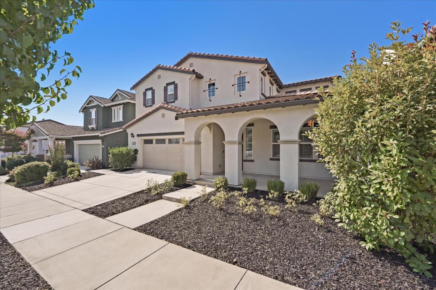1140 Ruby Way Gilroy, CA 95020 - Photo 3 of 54 a view of a white house with large windows and a small yard