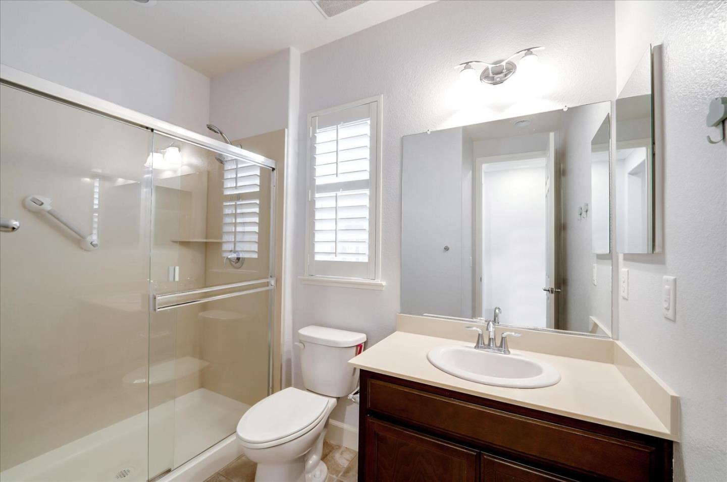 1140 Ruby Way Gilroy, CA 95020 - Photo 41 of 54 a bathroom with a granite countertop sink toilet a mirror and shower