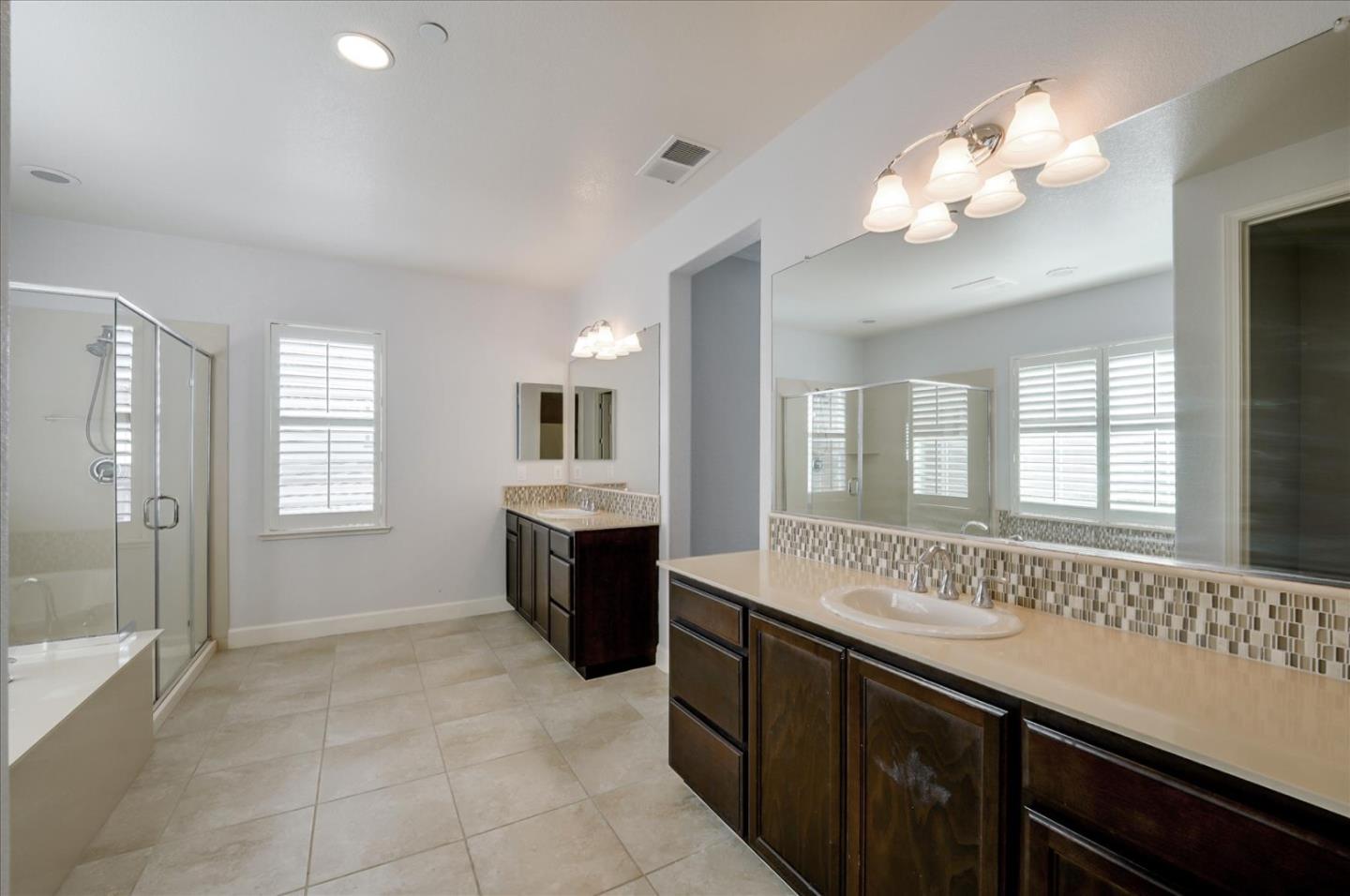 1140 Ruby Way Gilroy, CA 95020 - Photo 46 of 54 a spacious bathroom with a granite countertop sink a large mirror and a bathtub