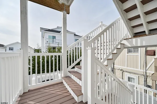 a view of staircase with lots of frames on wall and a window