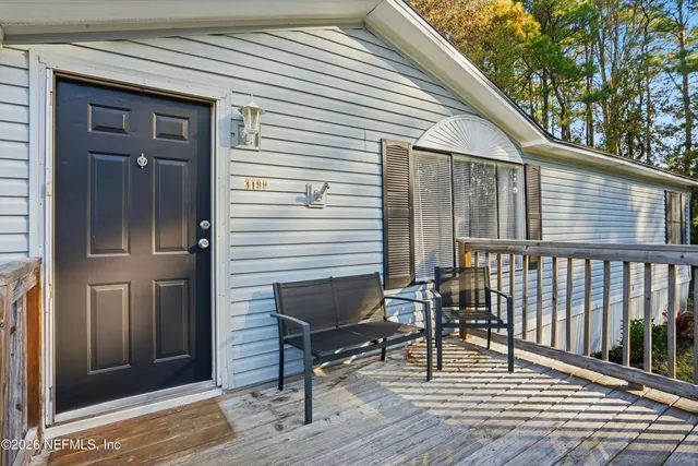 a view of a house with a deck and furniture
