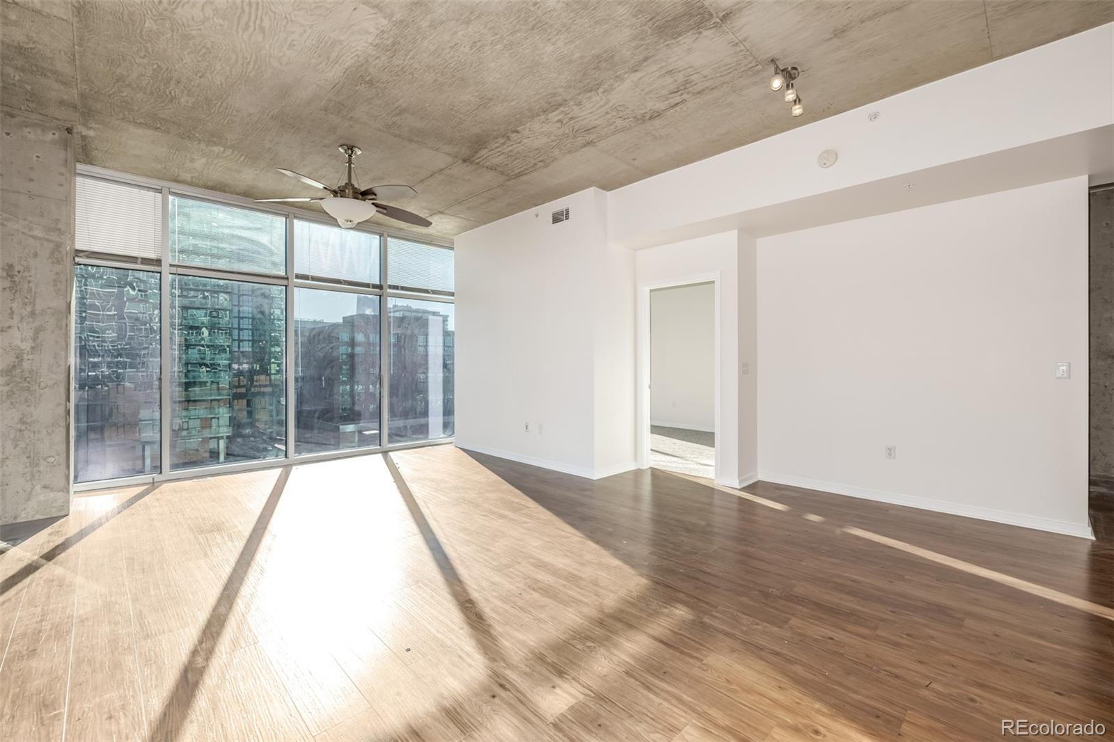 1700 Bassett Street, Unit 1012 Denver, CO 80202 - Photo 14 of 48 a view of an empty room with wooden floor and a window