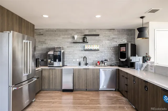 a kitchen with stainless steel appliances granite countertop a refrigerator and a sink