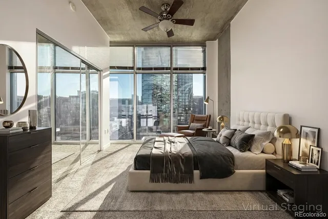 a living room with furniture a ceiling fan and a large window