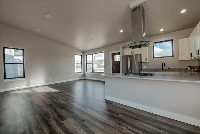 a view of an empty room with window and wooden floor