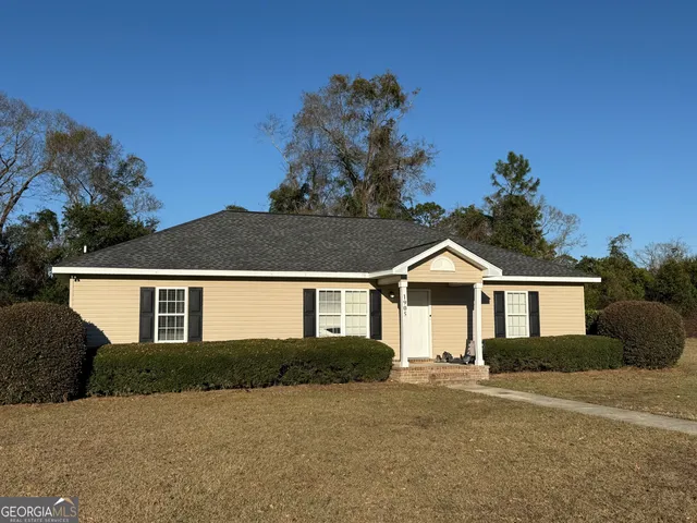 a front view of a house with a garden