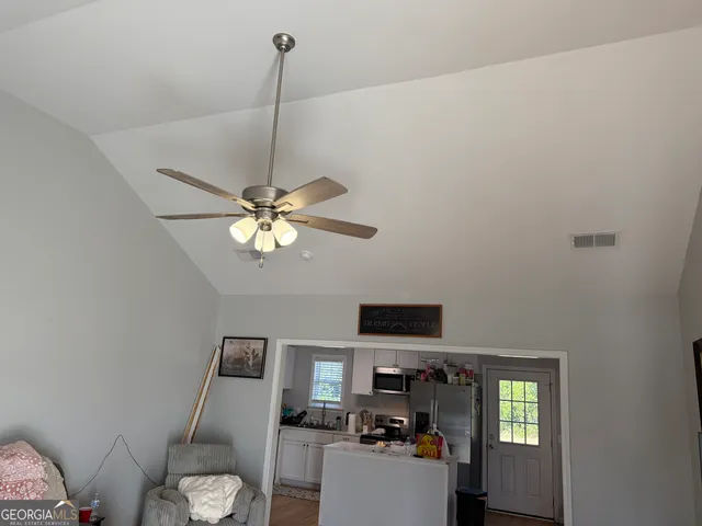 a work room with furniture a flat screen tv and a window