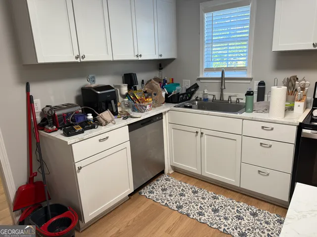 a kitchen with white cabinets and white appliances