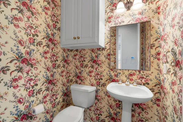 a bathroom with a sink and mirror with toilet