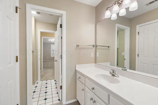 an empty room with a chandelier fan and closet area