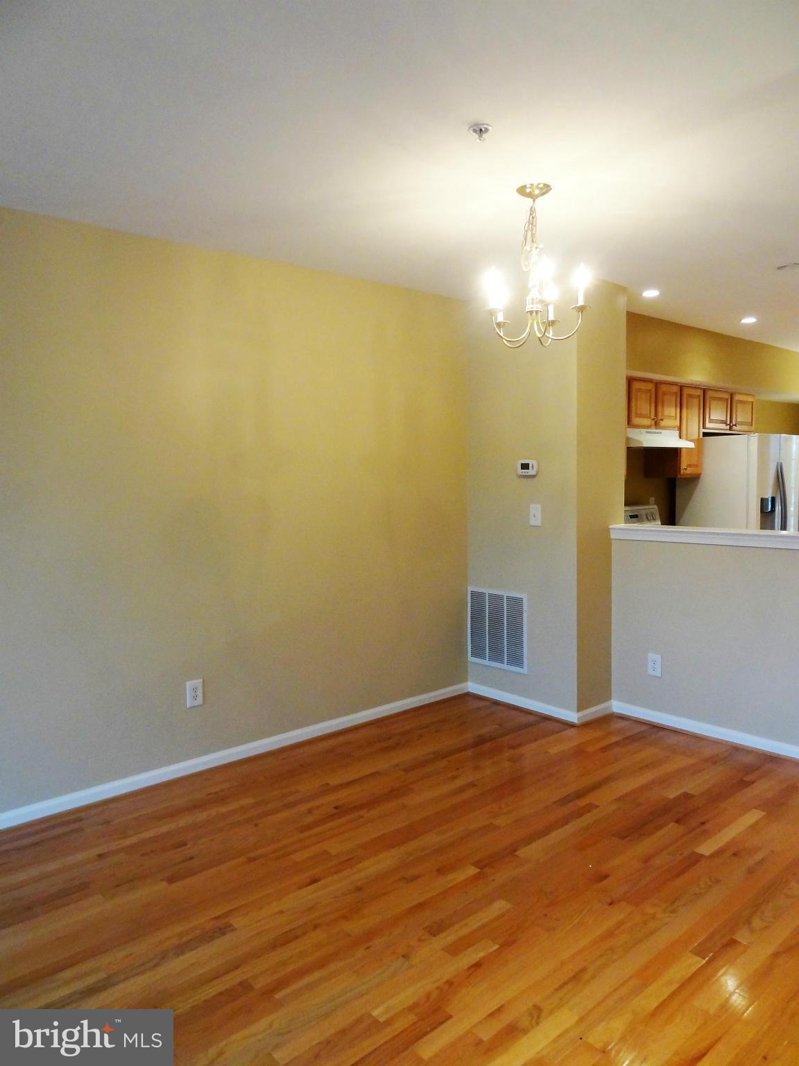 2032 University Boulevard West, Unit 3 Silver Spring, MD 20902 - Photo 4 of 16 an empty room with wooden floor and windows