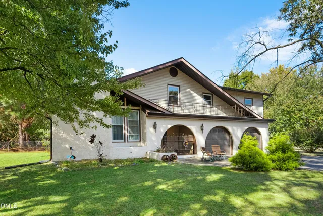 a front view of house with garden and trees