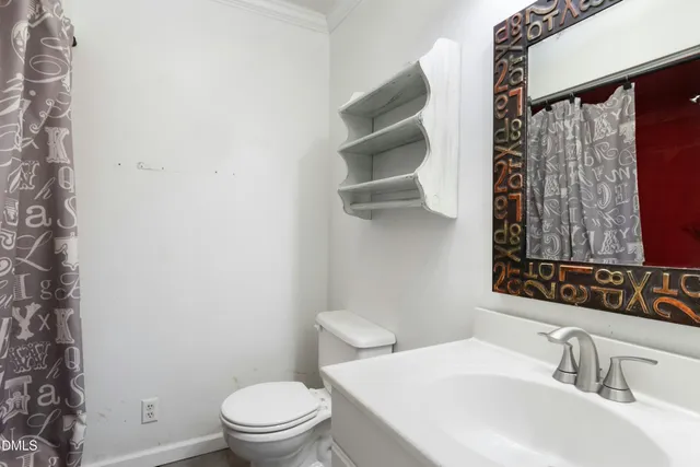 a bathroom with a sink a toilet and a mirror