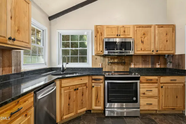 a kitchen with granite countertop a stove and a sink