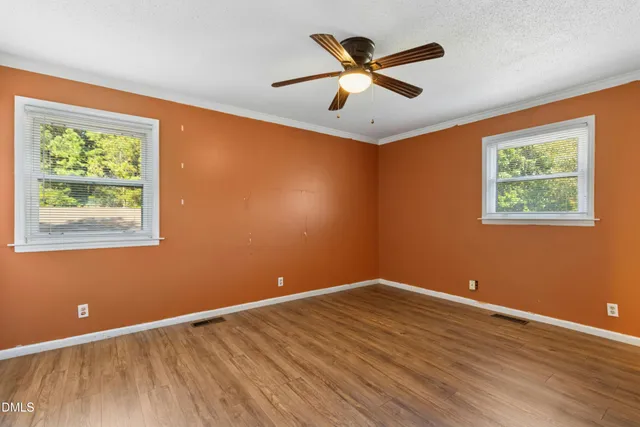 a view of a big room with wooden floor and windows