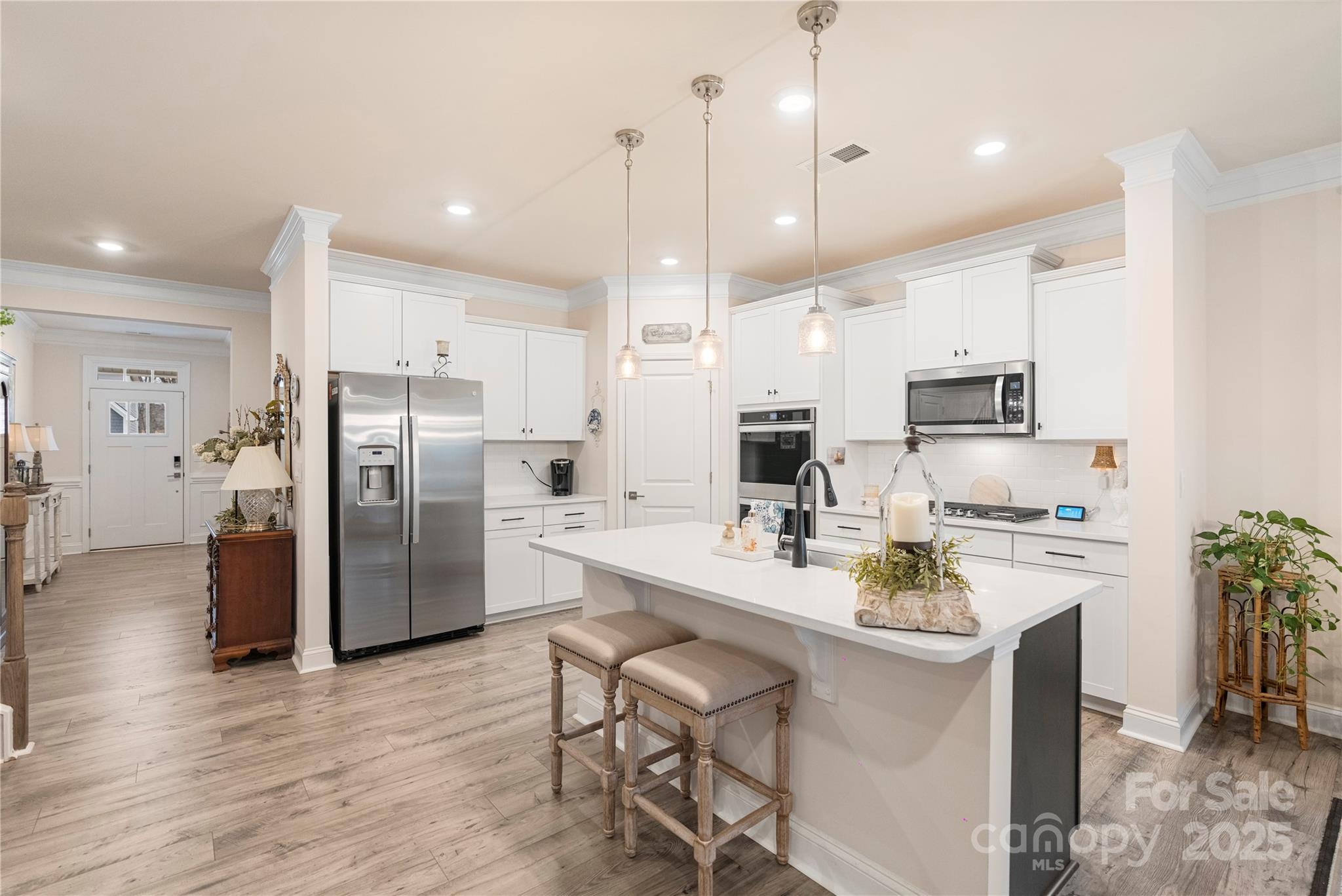 141 Rhuidean Court Troutman, NC 28166 - Photo 10 of 29 a kitchen with refrigerator a stove a sink and chairs