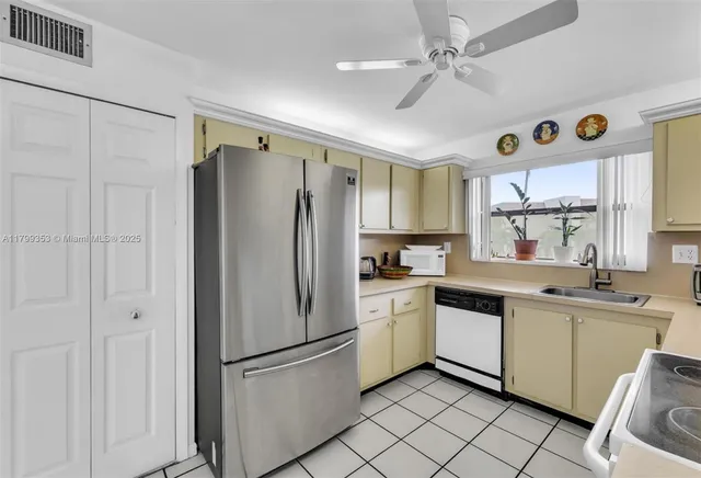 a kitchen with stainless steel appliances a refrigerator sink and cabinets