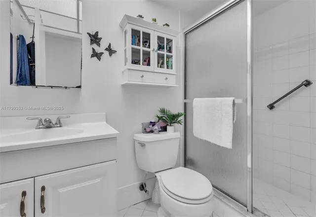 a bathroom with a sink a toilet a mirror and shower