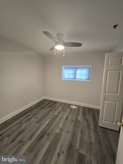 an empty room with wooden floor and window