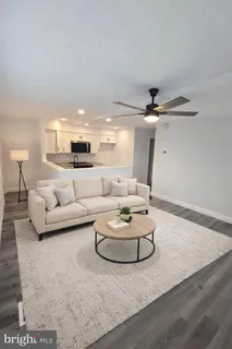 a living room with furniture and a ceiling fan