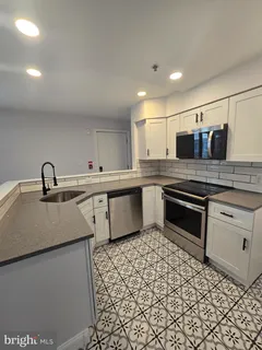 a kitchen with stainless steel appliances a sink and a refrigerator