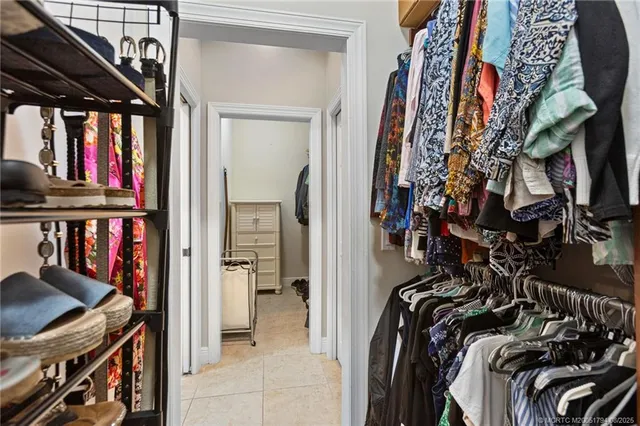 a view of walk in closet with clothes and shoes