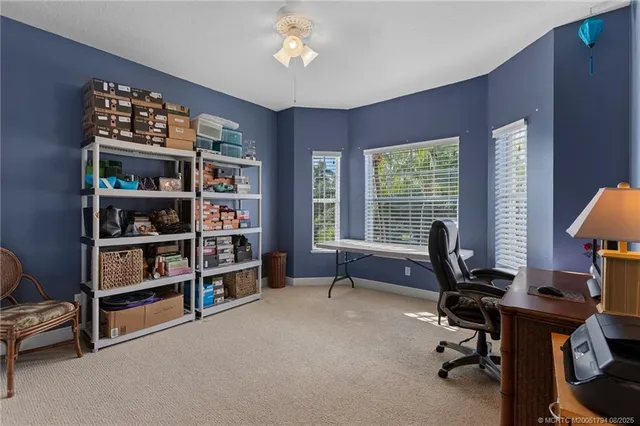 a view of a workspace with bookshelf and a window