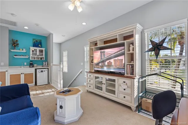 a living room with furniture a flat screen tv and kitchen view