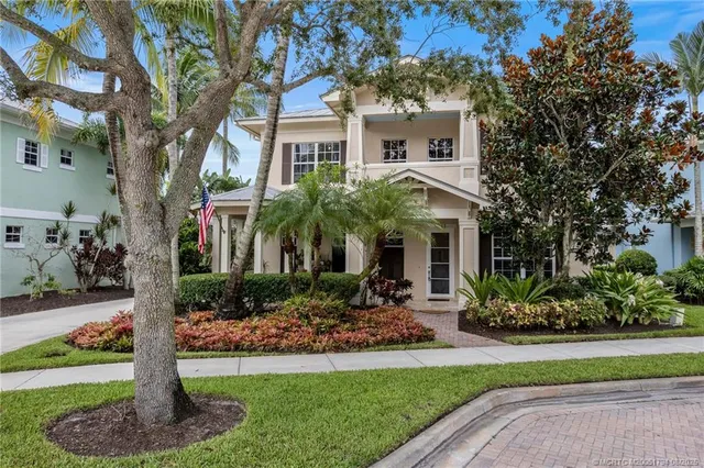a front view of a house with a yard and potted plants