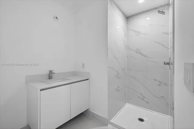 a bathroom with a granite countertop sink a toilet and shower