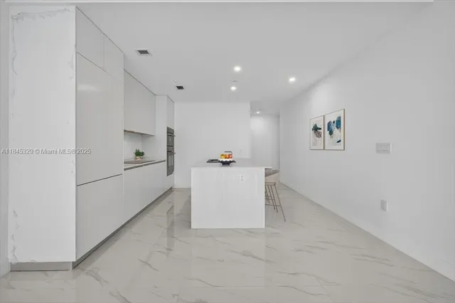 a view of kitchen with furniture and white appliances