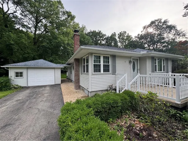 a front view of a house with a yard and trees