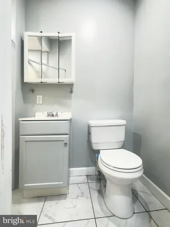 a bathroom with a toilet a sink and cabinets
