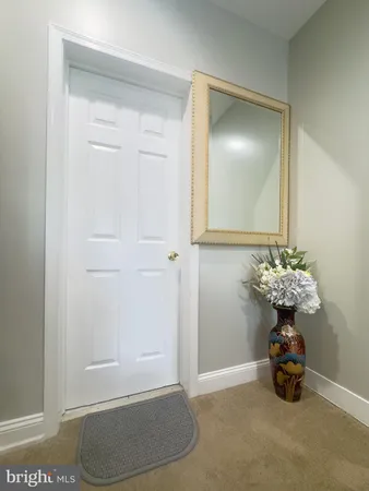 a view of a hallway to room with wooden floor