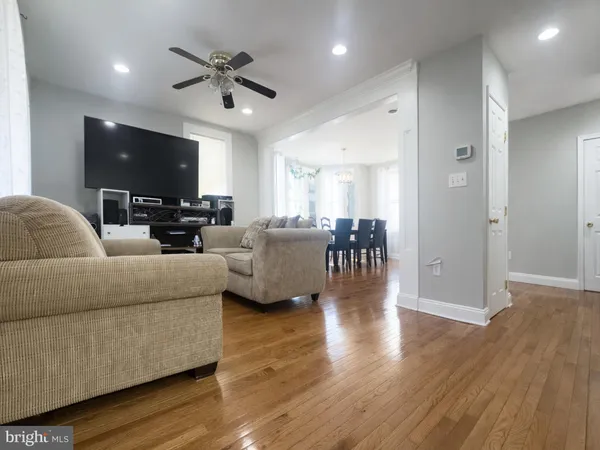 a living room with furniture ceiling fan and a flat screen tv