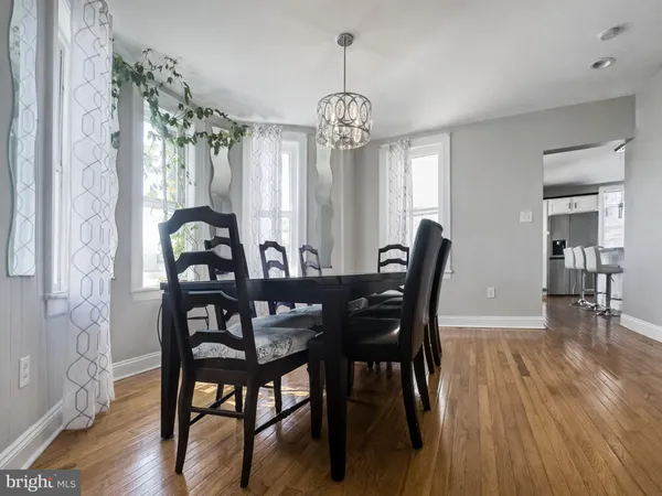 a view of a a dining room with furniture window and wooden floor