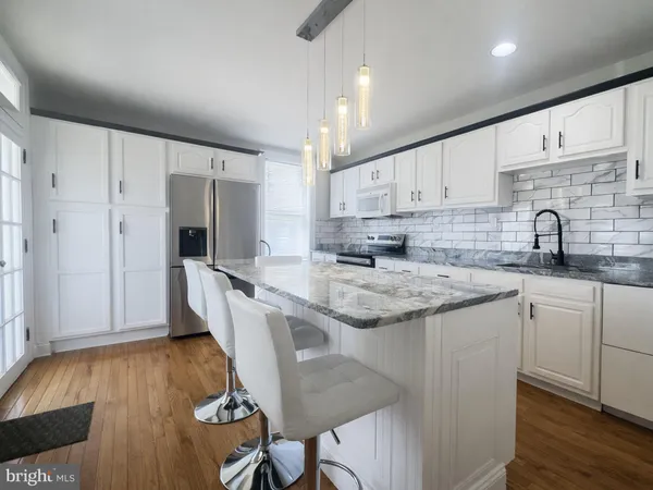 a kitchen with granite countertop a sink a counter space appliances and cabinets