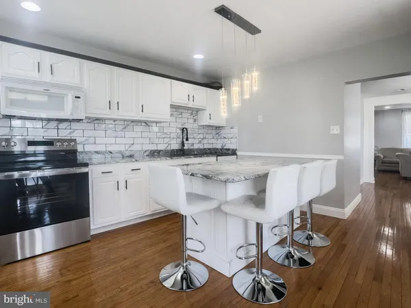 a kitchen with stainless steel appliances granite countertop a sink cabinets and wooden floor