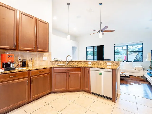 a kitchen with stainless steel appliances granite countertop a sink and a refrigerator