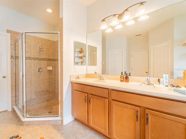 a bathroom with a double vanity sink mirror and shower
